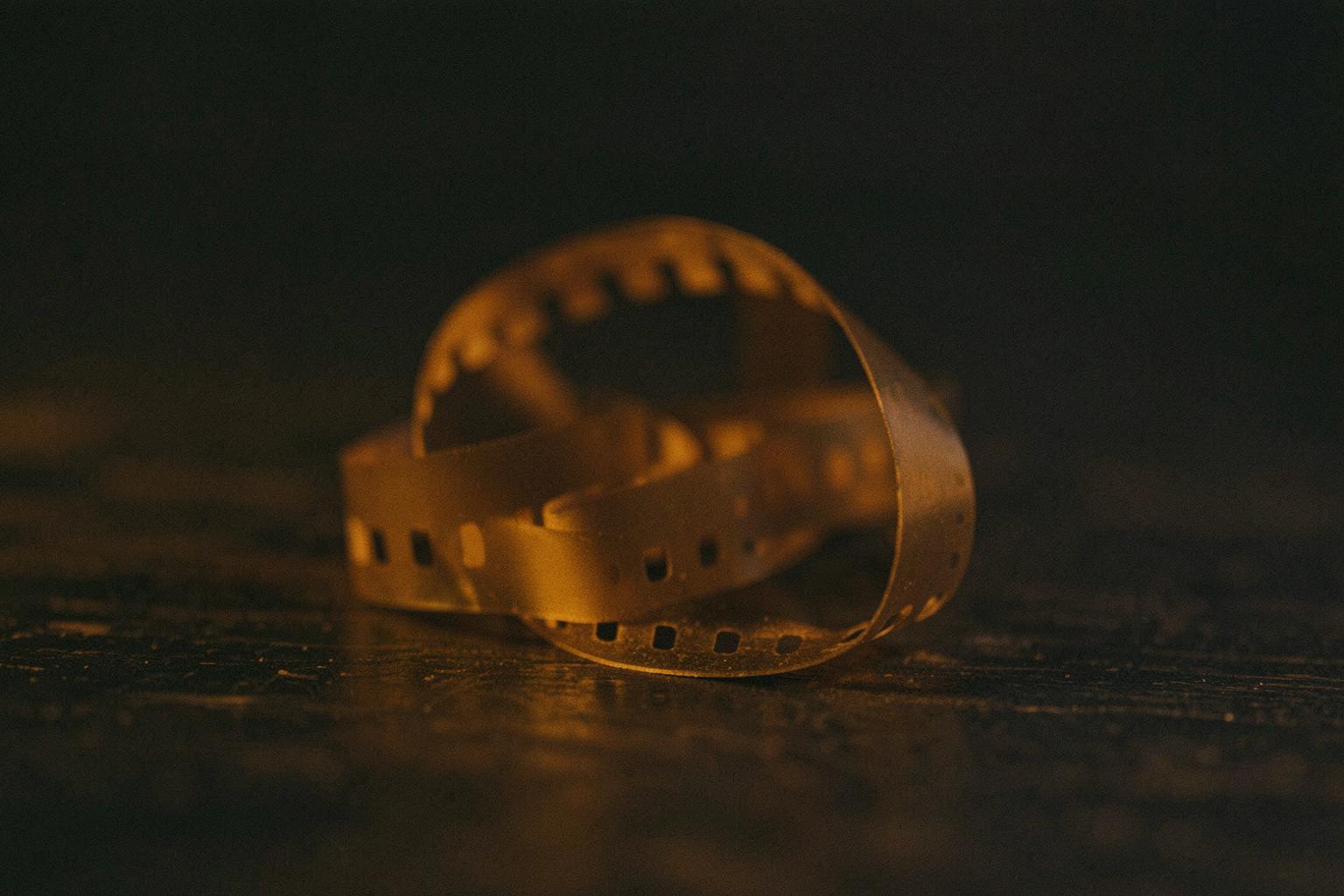 A curled film strip resting on dark wood