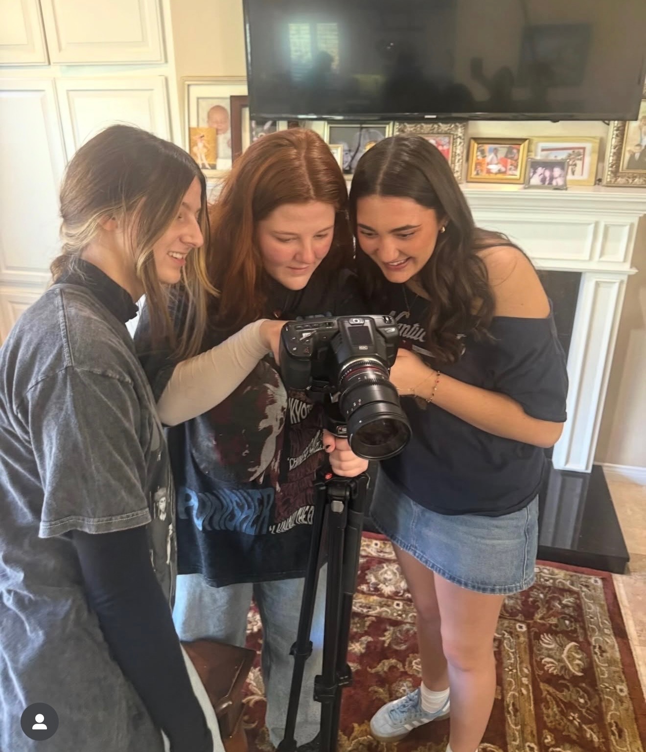 Three women checking the cinema camera screen on set